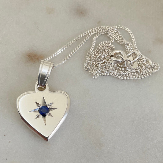 Silver heart set with a natural blue sapphire