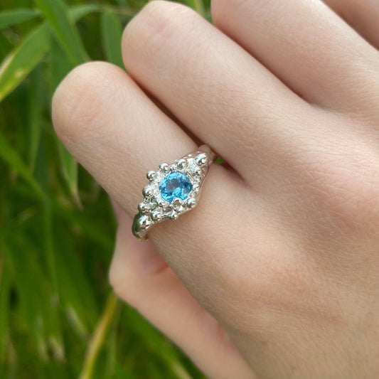 Swiss blue topaz organic sterling silver ring shown on hand.