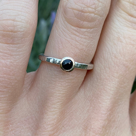 Blue sapphire stacking ring shown on hand model