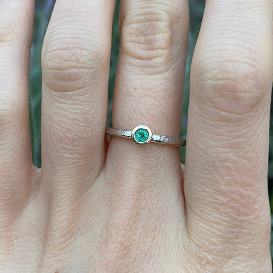 Emerald stacking ring with a touch of gold shown on model