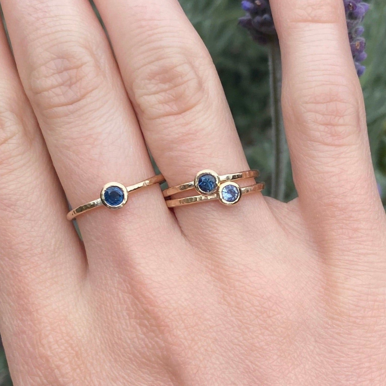 Gold rings set with sapphires shown on hand model